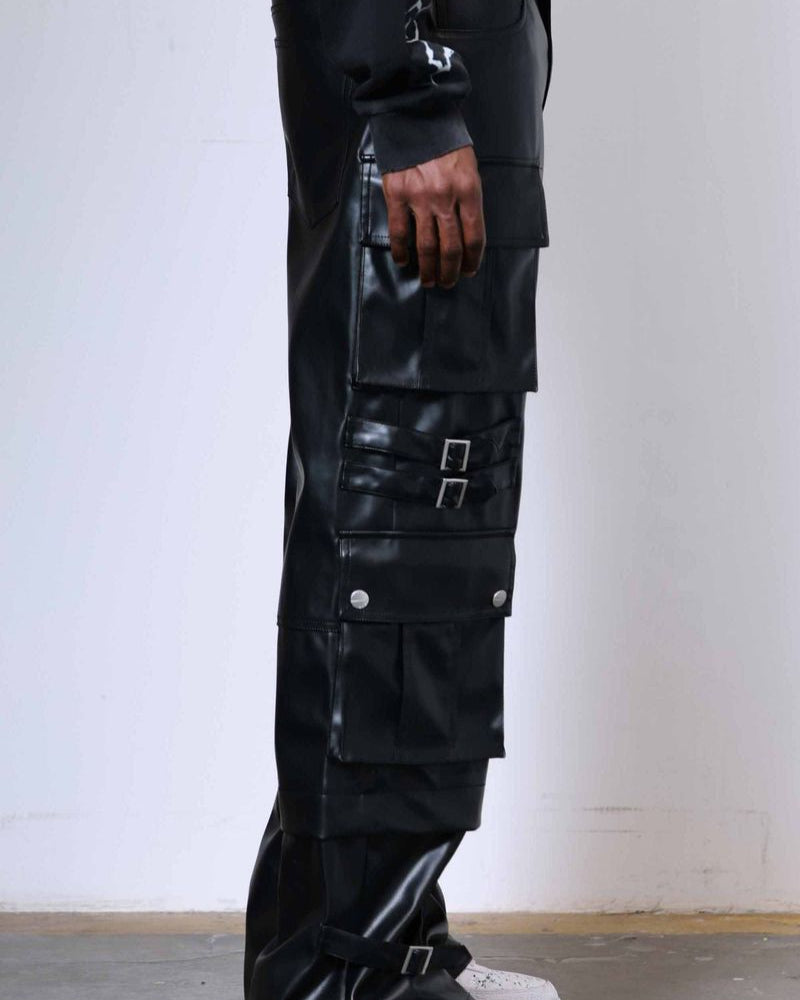 Person wearing black glossy cargo pants with a white background