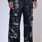 Person wearing black leather cargo pants with a plain background