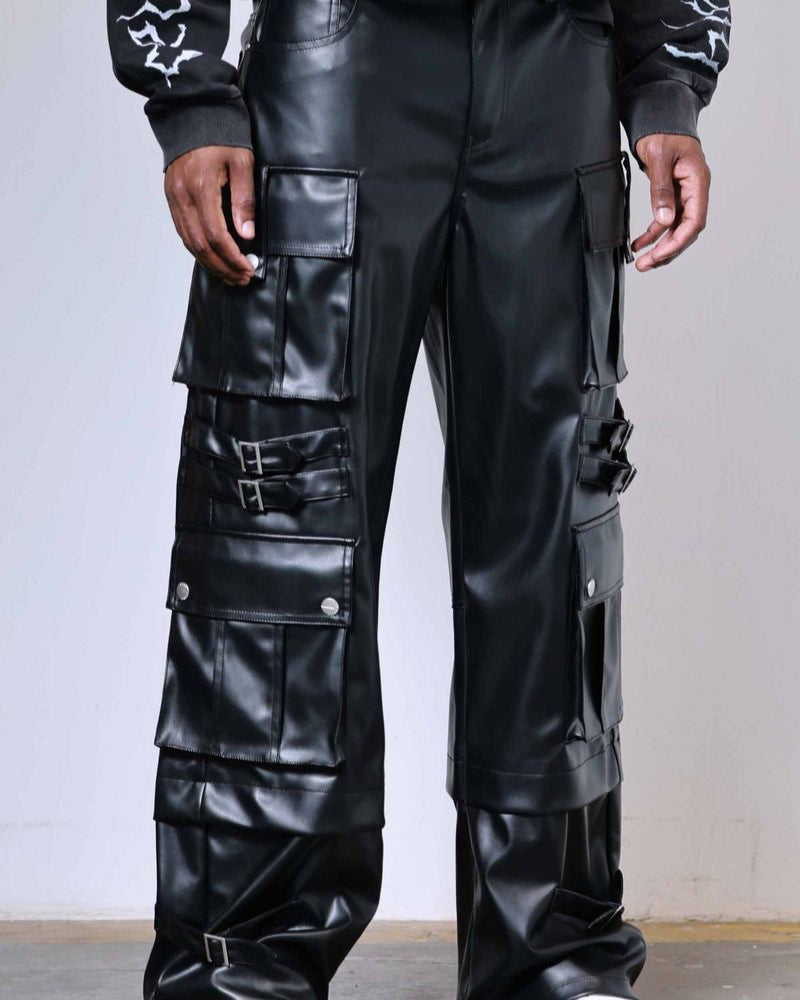Person wearing black leather cargo pants with a plain background