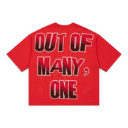 A red short-sleeve t-shirt shown from the back, featuring the text 'OUT OF MANY, ONE' in a bold black-to-red gradient font with a white outline.