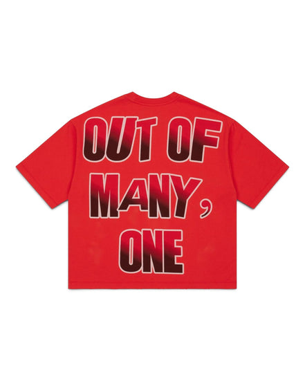 A red short-sleeve t-shirt shown from the back, featuring the text 'OUT OF MANY, ONE' in a bold black-to-red gradient font with a white outline.