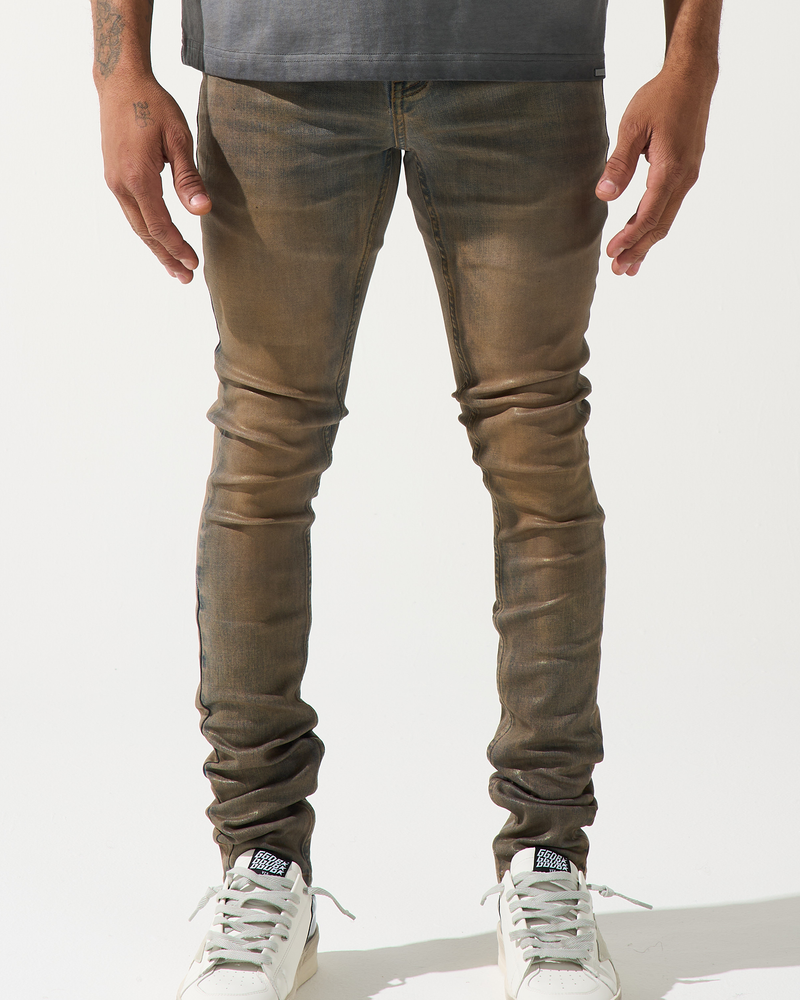 Person wearing brown leather pants and white sneakers on a white background