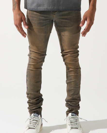 Person wearing brown leather pants and white sneakers on a white background