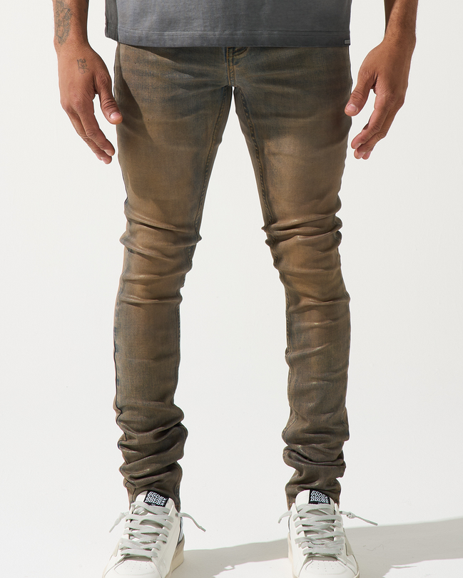 Person wearing brown leather pants and white sneakers on a white background