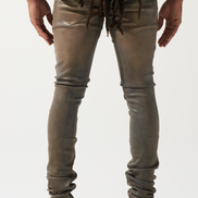Person wearing brown distressed jeans and white sneakers on a white background