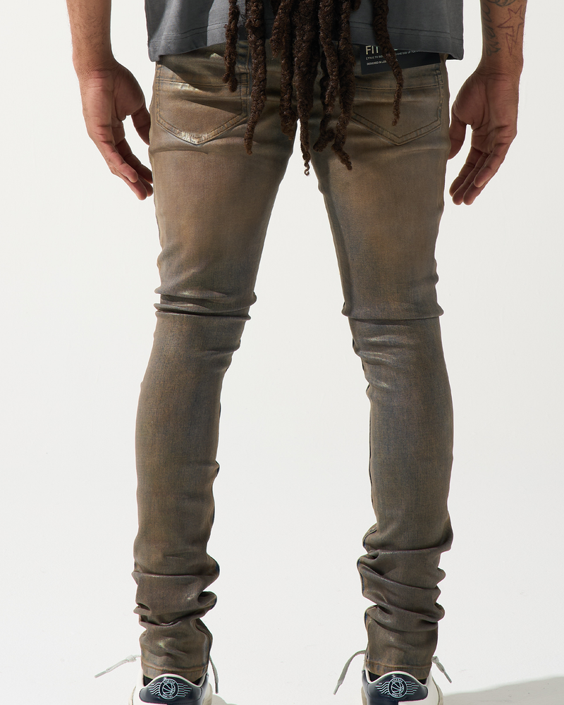 Person wearing brown distressed jeans and white sneakers on a white background