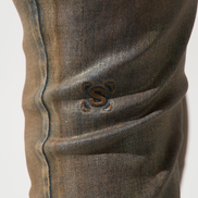Close-up of a brown denim jeans with a brand logo on a white background