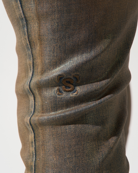 Close-up of a brown denim jeans with a brand logo on a white background