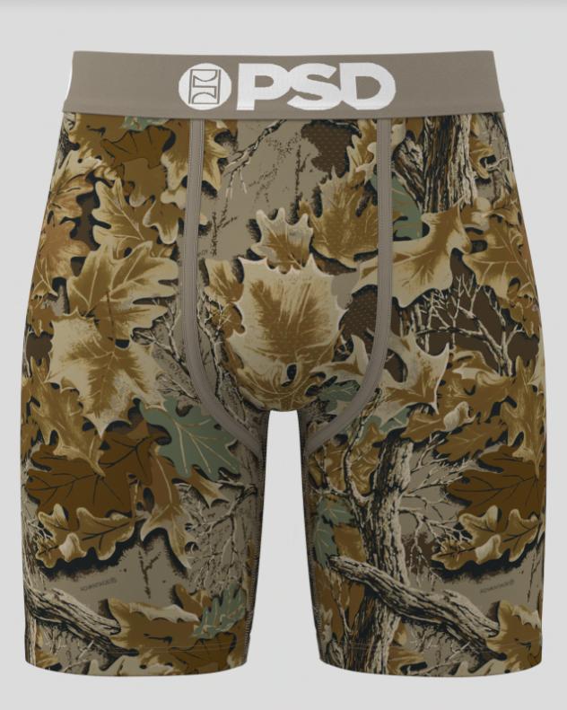 Camouflage-patterned shorts with 'PSD' branding on a gray background