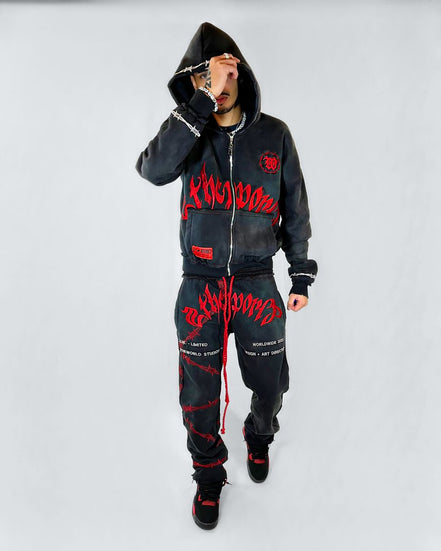 Person wearing a black hoodie and pants with red text on a white background