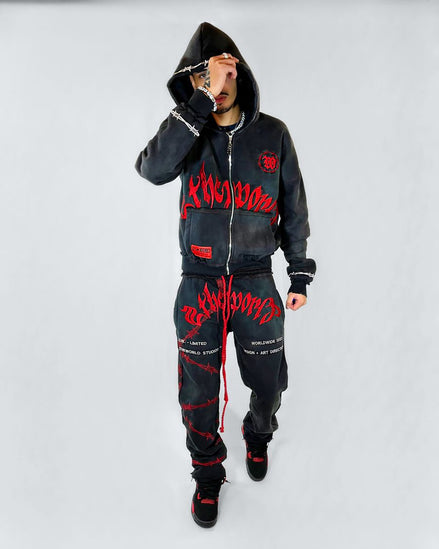 Person wearing a black hoodie and pants with red text on a white background