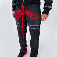 Person wearing black and red tracksuit with visible branding on a white background