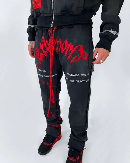 Person wearing black and red tracksuit with visible branding on a white background