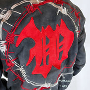 Black jacket with red and white design on the back, featuring barbed wire and abstract shapes.