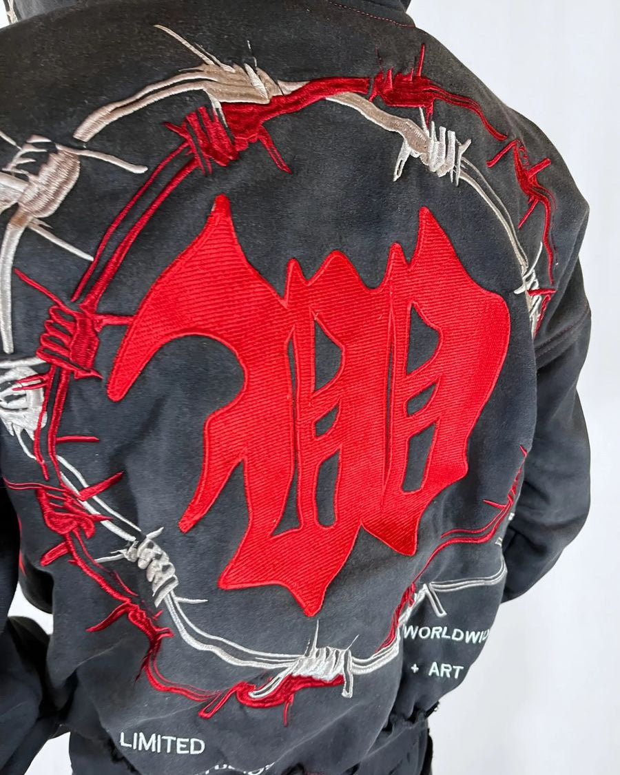 Black jacket with red and white design on the back, featuring barbed wire and abstract shapes.