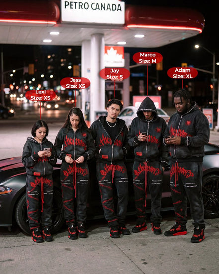 Five people wearing matching black outfits with red accents standing in front of a Petro Canada gas station at night.