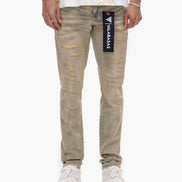 Person wearing beige distressed jeans with a brand logo on a white background