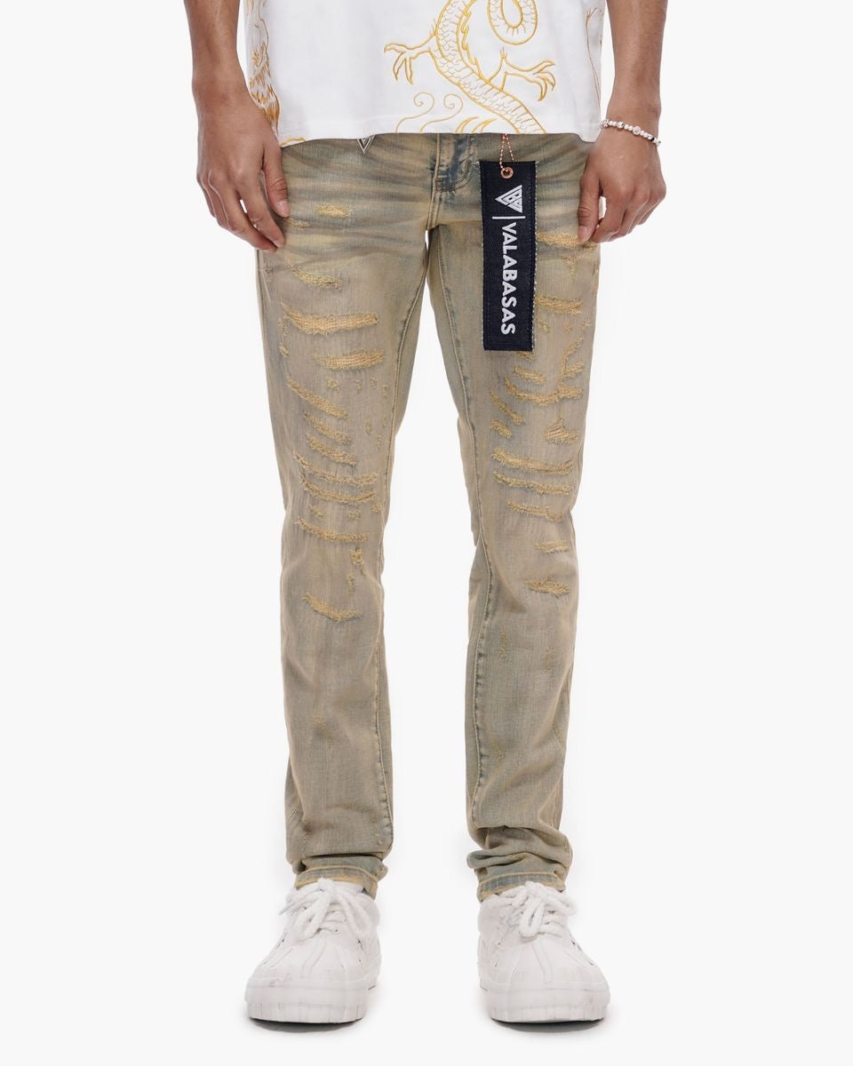 Person wearing beige distressed jeans with a brand logo on a white background