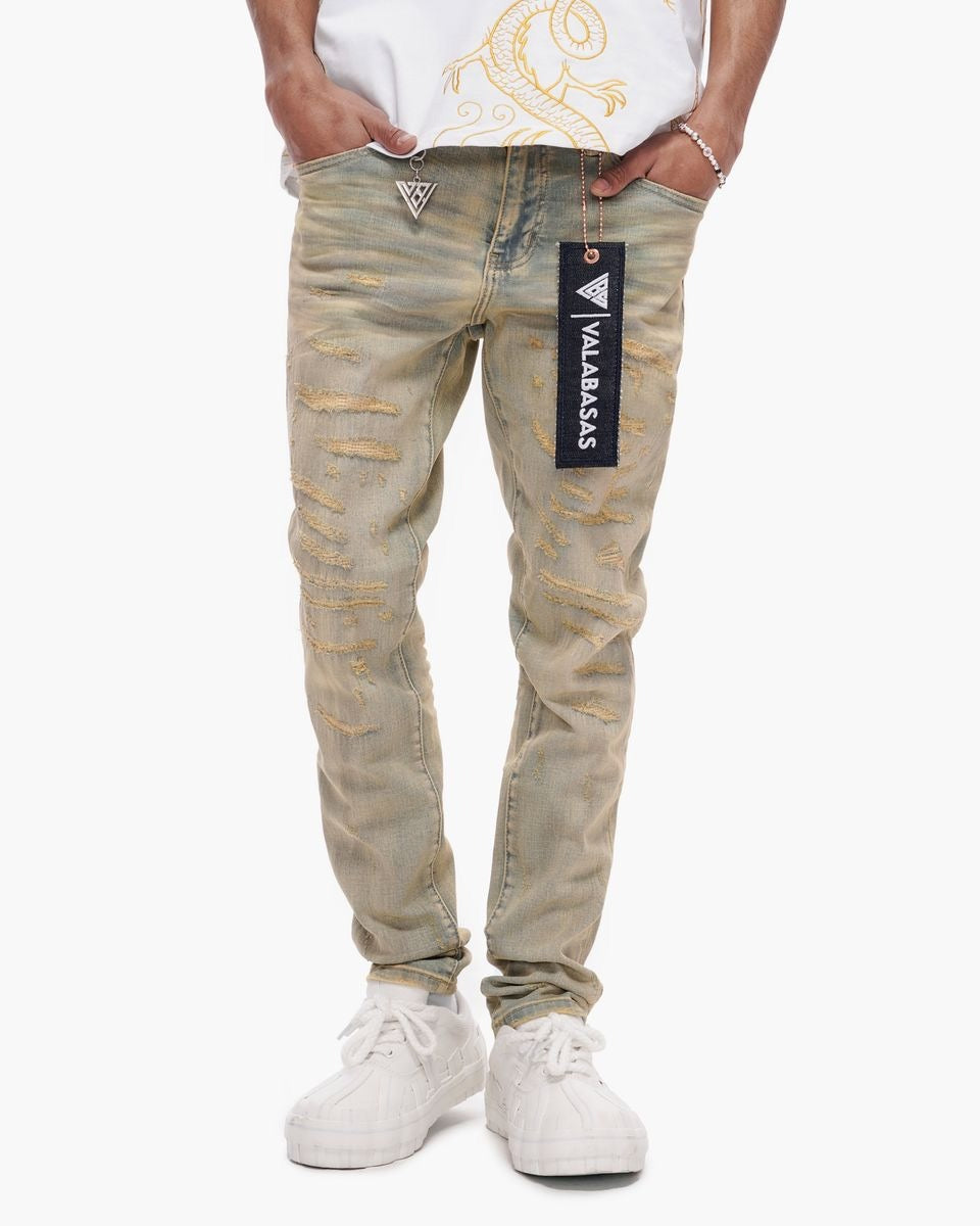 Person wearing beige distressed jeans with a brand label on a white background