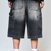 Person wearing black gradient shorts with a plain background
