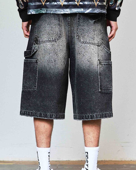 Person wearing black gradient shorts with a plain background