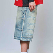Person wearing a red jacket, black shirt, blue denim skirt, white sneakers, and socks with text.
