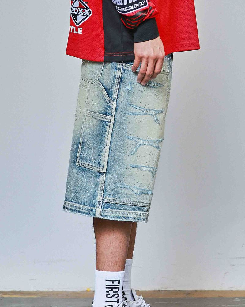 Person wearing a red jacket, black shirt, blue denim skirt, white sneakers, and socks with text.