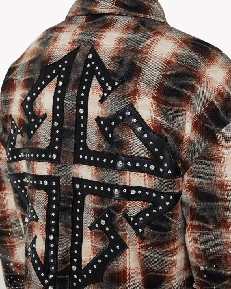 Plaid shirt with decorative black lettering and studs on a neutral background