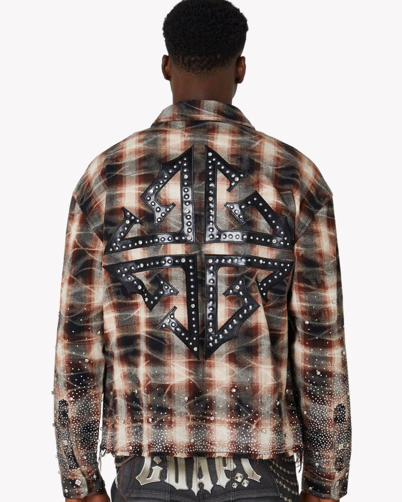 Person wearing a plaid shirt with star designs and studded details on the back, on a white background.