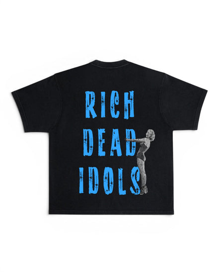 A black short-sleeve t-shirt with a graphic print on the back featuring the text 'RICH DEAD IDOLS' in distressed blue letters and a grayscale illustration of Marilyn Monroe holding a microphone.