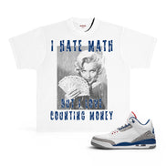 A white graphic t-shirt featuring a black-and-white photo of Marilyn Monroe holding cards with blue text reading 'I HATE MATH BUT I LOVE COUNTING MONEY', shown next to a white sneaker with blue and gray accents on a white background.