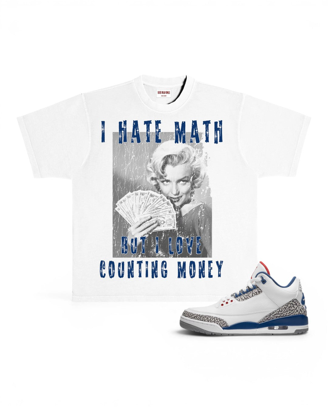 A white graphic t-shirt featuring a black-and-white photo of Marilyn Monroe holding cards with blue text reading 'I HATE MATH BUT I LOVE COUNTING MONEY', shown next to a white sneaker with blue and gray accents on a white background.