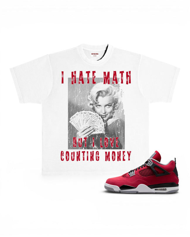 A white graphic T-shirt featuring a black-and-white Marilyn Monroe print with red distressed text reading 'I HATE MATH BUT I LOVE COUNTING MONEY,' shown alongside the Toro Air Jordan 4 sneaker on a white background.
