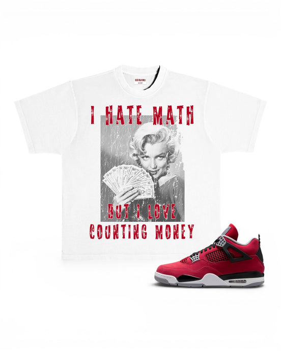 A white graphic T-shirt featuring a black-and-white Marilyn Monroe print with red distressed text reading 'I HATE MATH BUT I LOVE COUNTING MONEY,' shown alongside the Toro Air Jordan 4 sneaker on a white background.