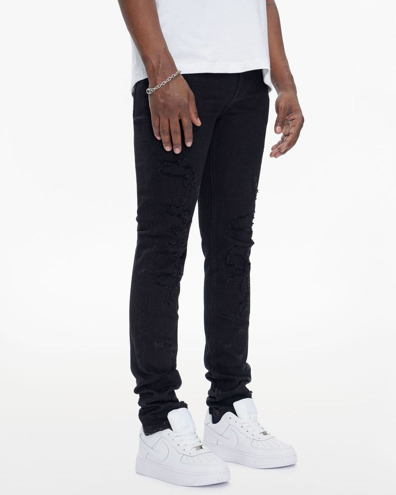 Person wearing black jeans and white sneakers on a white background
