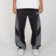 Person wearing black and white striped pants with a brand logo on a white background