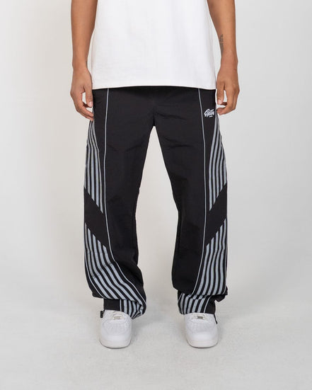 Person wearing black and white striped pants with a brand logo on a white background