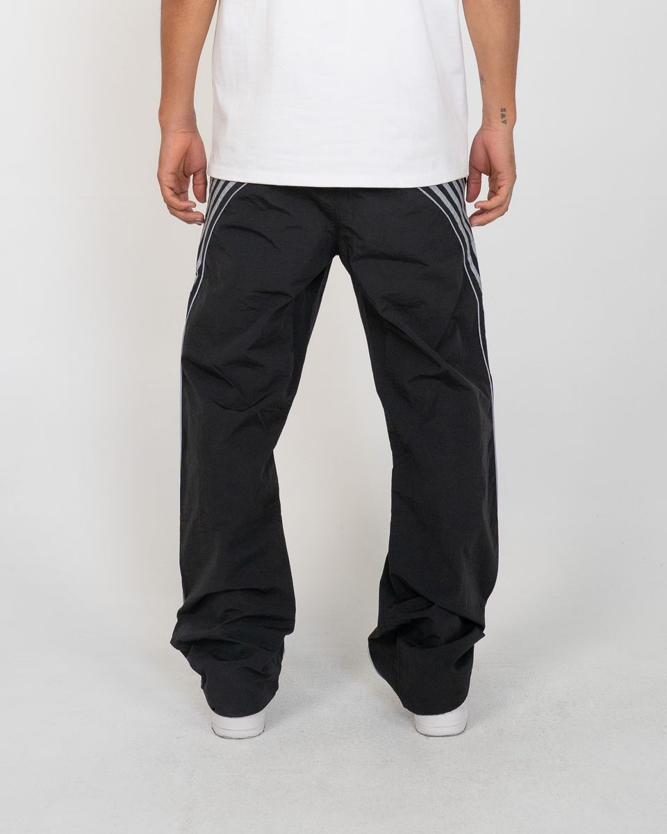 Person wearing black pants with white stripes on a white background