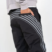 Black pants with gray stripes worn by a person on a white background
