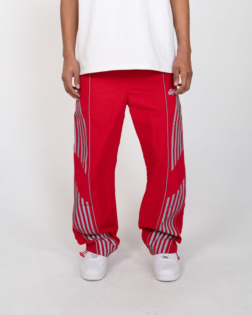 Red pants with white stripes worn by a person on a white background