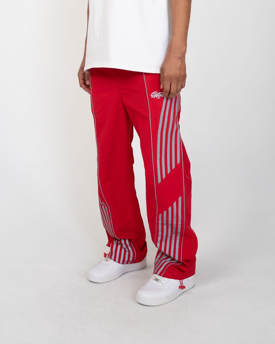 Red pants with white stripes worn by a person on a white background