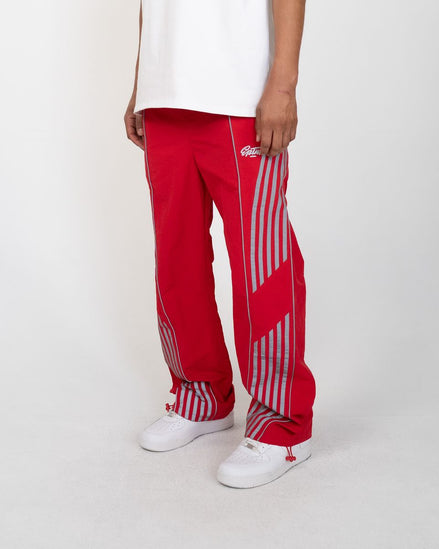 Red pants with white stripes worn by a person on a white background