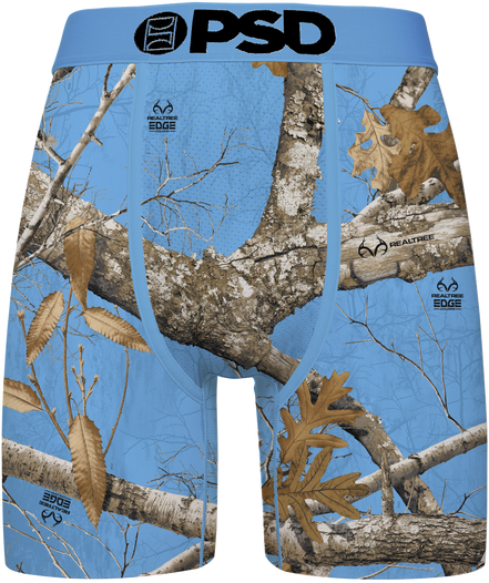 Blue camouflage boxer briefs featuring a Realtree Edge woodland camo pattern with branches, leaves, and bark, and a black 'PSD' logo printed on the front waistband.