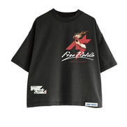 A black oversized short-sleeve t-shirt featuring a red and white graphic print on the front with the text 'Free Refills' and an anime character. It has a small white brand label on the bottom right hem and a small graphic patch on the bottom left hem, shown against a plain white background.