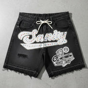 Black shorts with white embellishments on a gray surface