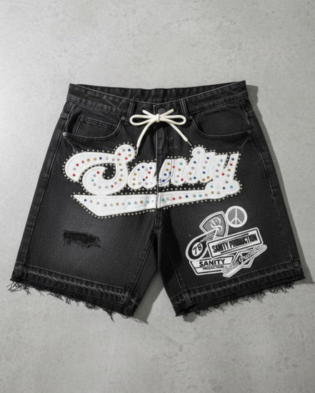 Black shorts with white embellishments on a gray surface