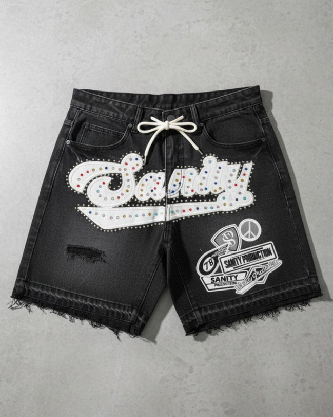 Black shorts with white embellishments on a gray surface