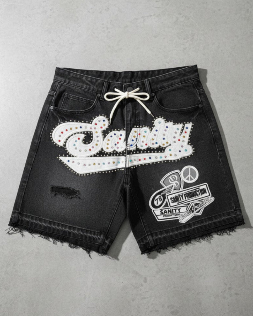 Black shorts with white embellishments on a gray surface