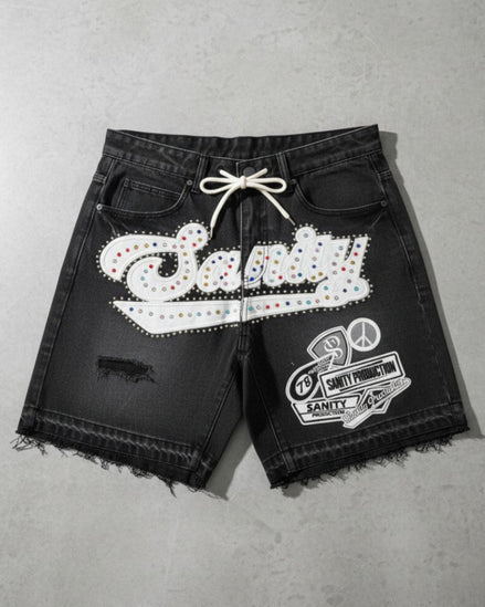 Black shorts with white embellishments on a gray surface