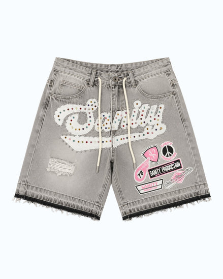 Gray denim shorts with patches and branding on a white background
